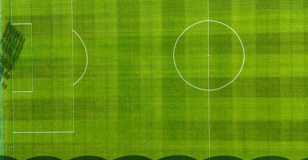 Drone view of a green football field in Jönköping, Sweden, showcasing the pitch from above.